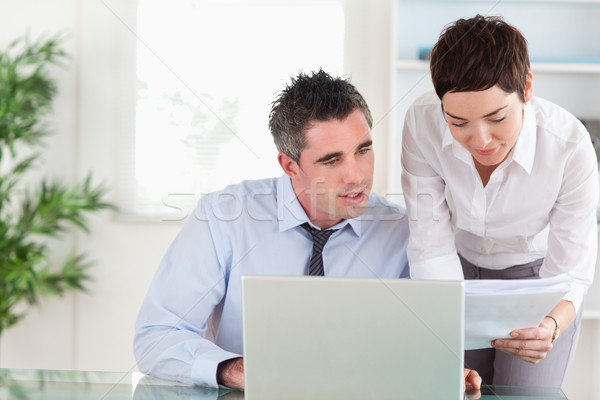 Stock photo: Coworkers comparing a blueprint document to an electronic one in an office