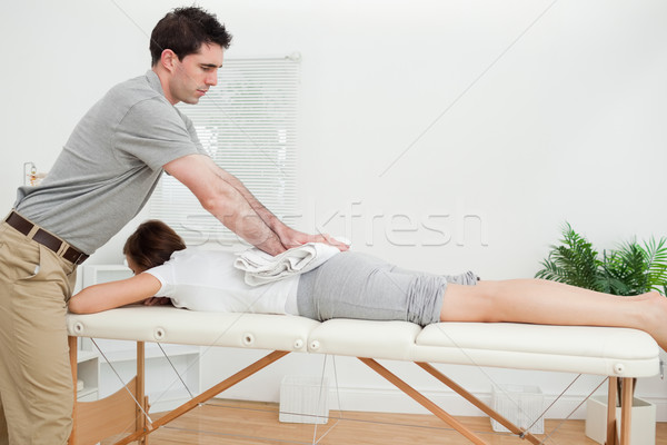 Woman lying while being massaged with a towel in a room Stock photo © wavebreak_media