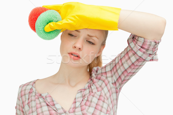 Woman wiping her forehead while holding sponges Stock photo © wavebreak_media