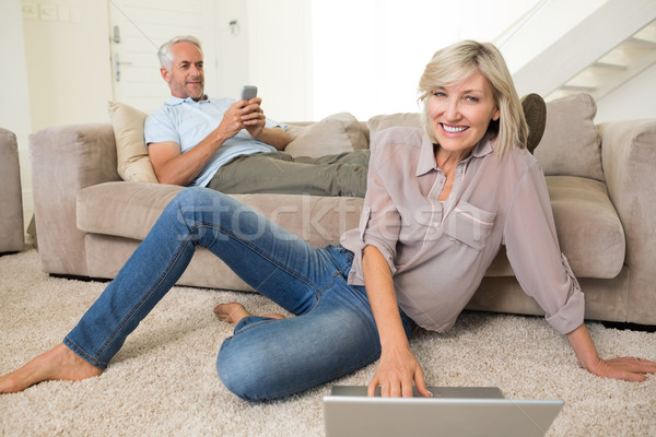 Stock photo: Couple with laptop and cellphone in living room at home