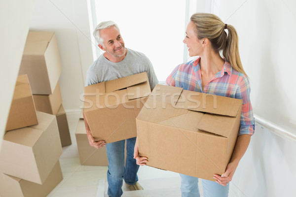 Happy couple carrying cardboard moving boxes  Stock photo © wavebreak_media