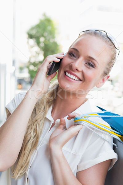 Csinos szőke nő készít hívás tart bevásárlótáskák Stock fotó © wavebreak_media