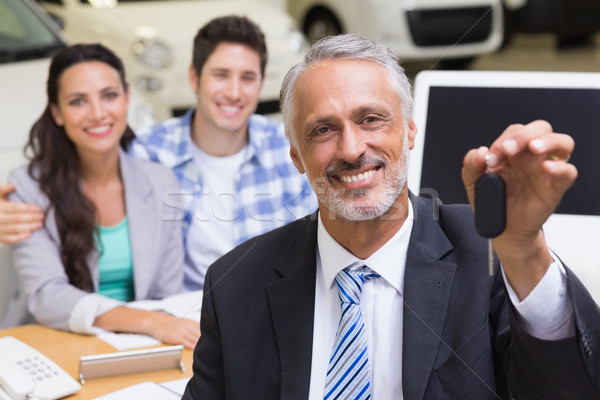 Smiling businessman showing a car key Stock photo © wavebreak_media