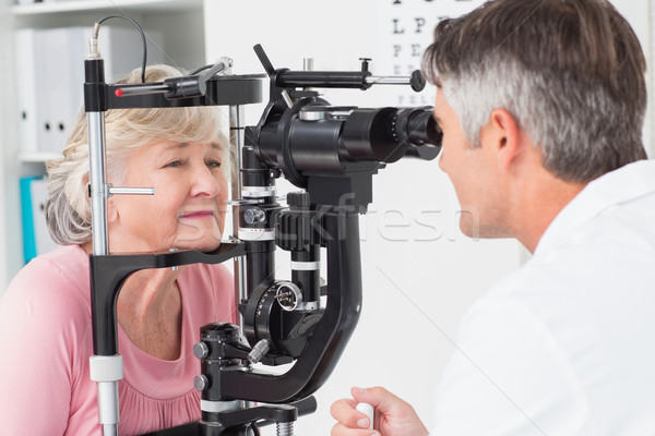 Optician examining senior female patient through slit lamp Stock photo © wavebreak_media