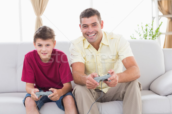 Father and son playing video game on sofa Stock photo © wavebreak_media