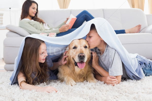 Stock photo: Siblings with dog under blanket