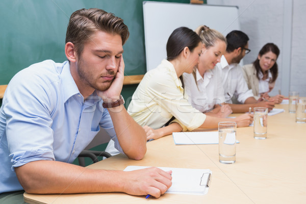 Buisness people working with man sleeping next to them Stock photo © wavebreak_media