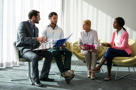 Senior man looking at friends talking while sitting on chair Stock photo © wavebreak_media