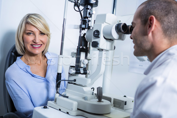 Optometrist examining female patient on slit lamp Stock photo © wavebreak_media