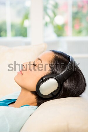 Uśmiechnięta kobieta słuchawki bed domu kobieta muzyki Zdjęcia stock © wavebreak_media