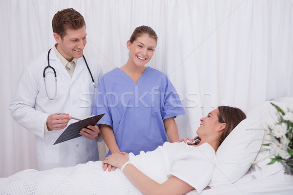 Doctors bringing good news to bedridden patient Stock photo © wavebreak_media