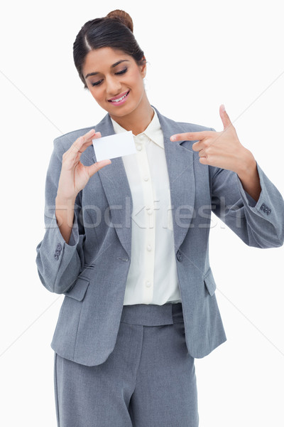 Smiling tradeswoman pointing at blank business card against a white background Stock photo © wavebreak_media