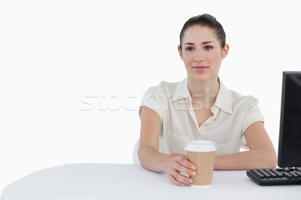 Businesswoman drinking a takeaway coffee while using a computer against a white background Stock photo © wavebreak_media