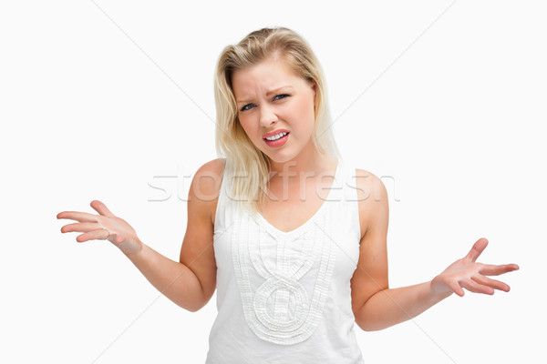 Upset woman standing while extending her arms against a white background Stock photo © wavebreak_media