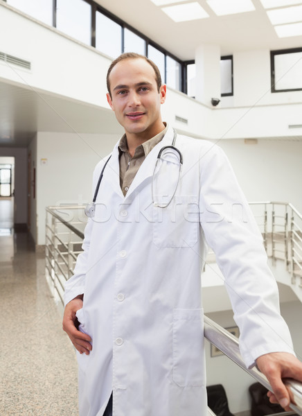 Doctor proudly smiling in hospital hallway Stock photo © wavebreak_media