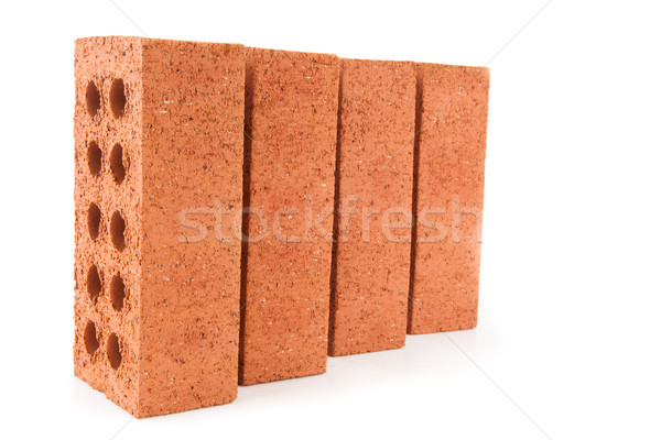 Stock photo: Four red bricks positioned in a row with a white background