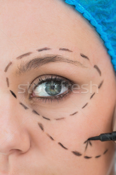 Surgeon writing on part of a woman's face in the white background Stock photo © wavebreak_media