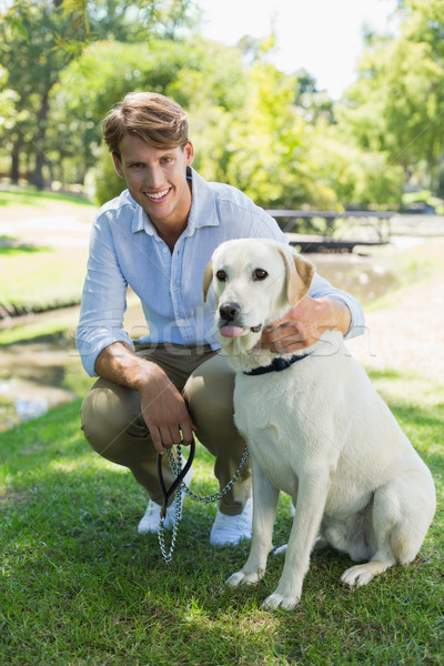 Handsome man with his labrador in the park smiling at camera Stock photo © wavebreak_media