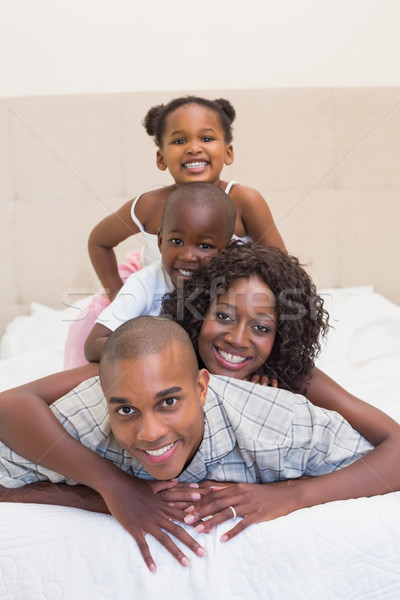 Familia feliz sonriendo cámara junto cama casa Foto stock © wavebreak_media