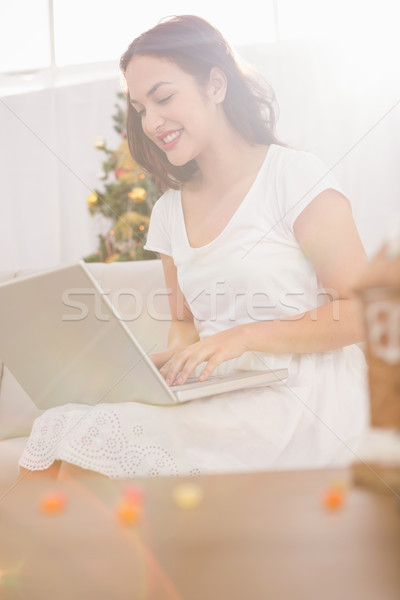 Smiling brunette typing on her laptop on the couch Stock photo © wavebreak_media