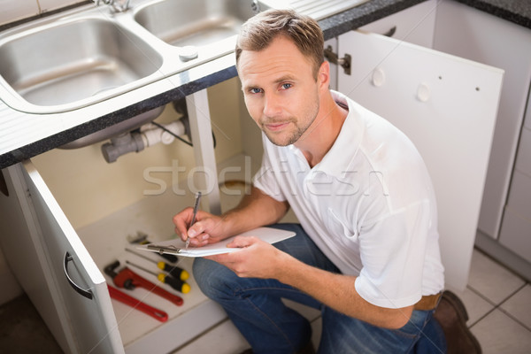 Plumber crouching and taking notes Stock photo © wavebreak_media