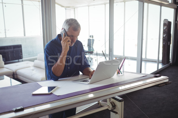 Işadamı konuşma telefon dizüstü bilgisayar kullanıyorsanız ofis olgun Stok fotoğraf © wavebreak_media