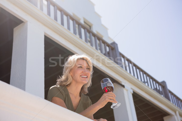 Blond Frau halten rot Weinglas Balkon Stock foto © wavebreak_media