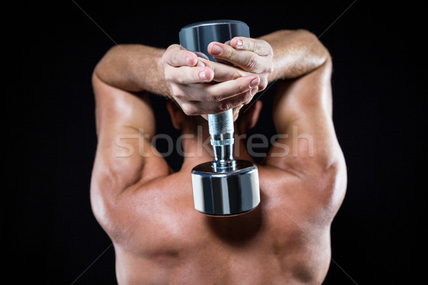 Rear view of shirtless sports player working out with dumbbell Stock photo © wavebreak_media