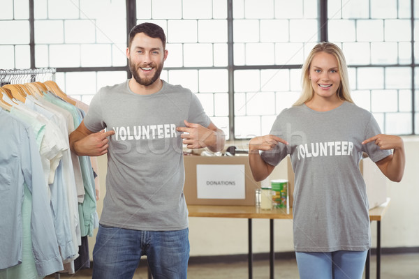 Stock photo: Portrait of volunteers showing volunteer text on tshirts 