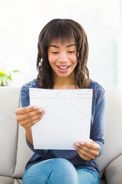 Casual smiling woman reading paper Stock photo © wavebreak_media