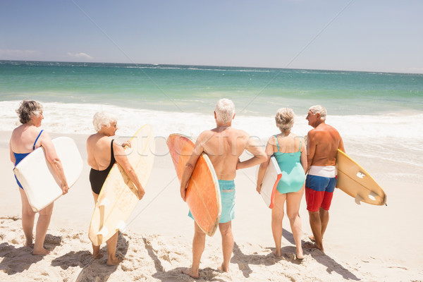 Stock photo: Senior friends holding surfboard