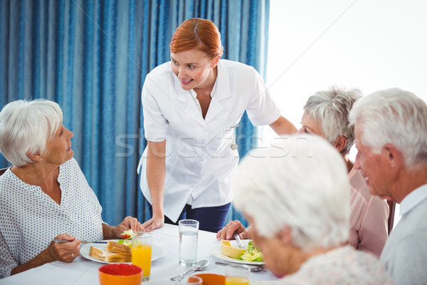 Glimlachend verpleegkundige naar senior persoon ontbijt Stockfoto © wavebreak_media