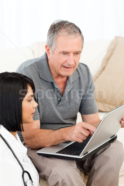 Olgun adam hemşire bakıyor dizüstü bilgisayar ev kadın Stok fotoğraf © wavebreak_media
