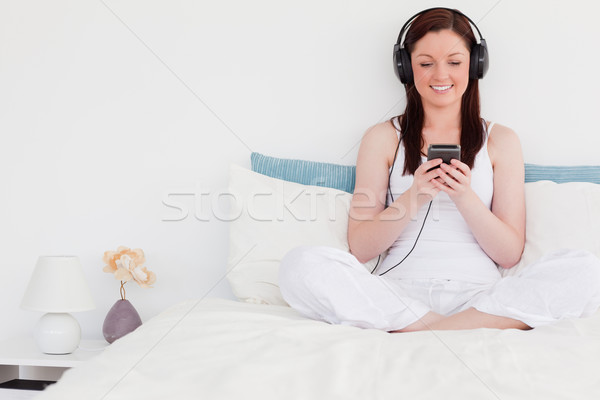 Vonzó nő zenét hallgat fejhallgató ül ágy Stock fotó © wavebreak_media