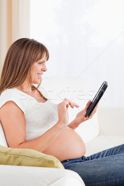 привлекательный беременная женщина расслабляющая компьютер таблетка сидят Сток-фото © wavebreak_media