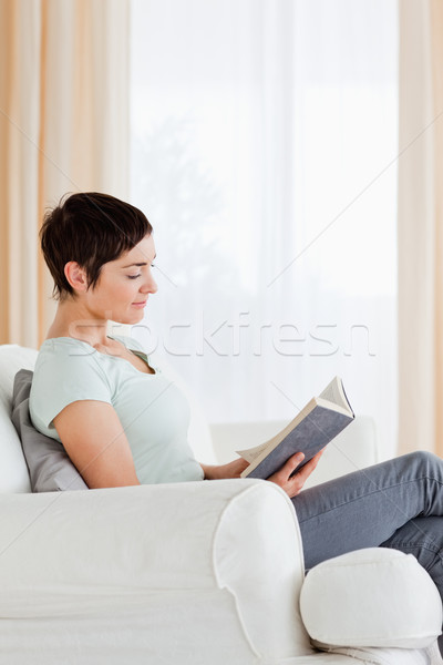 Portrait of a short-haired woman reading a book in her liviing room Stock photo © wavebreak_media