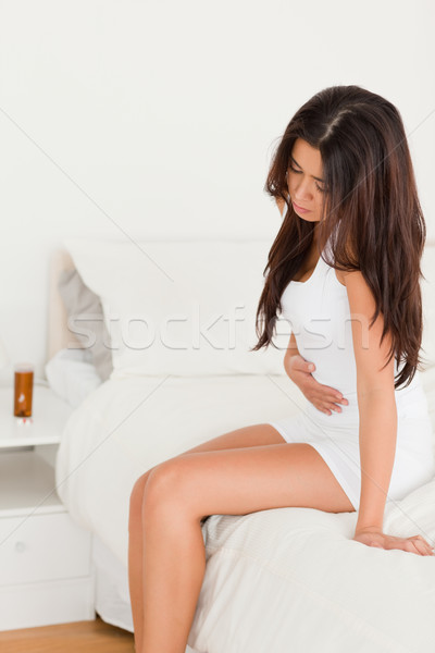 goodlooking woman having stomach ache in bedroom Stock photo © wavebreak_media