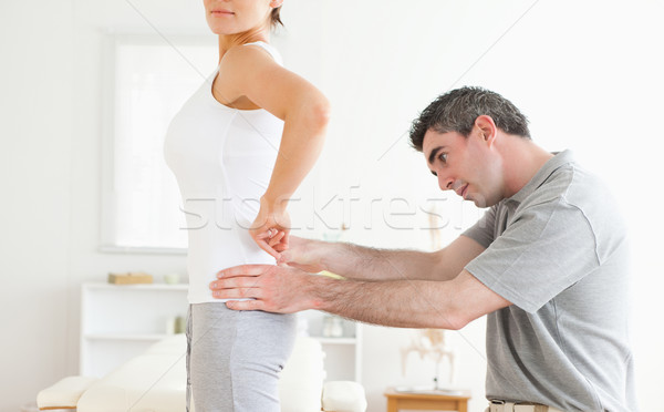 Stock photo: Chiropractor examining a cute woman's back in a room