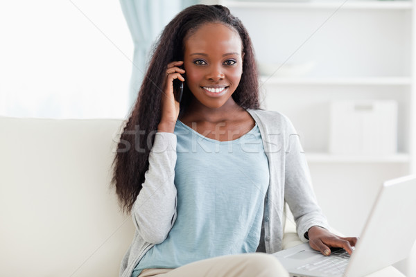 Foto stock: Sorrindo · sofá · caderno · internet · laptop