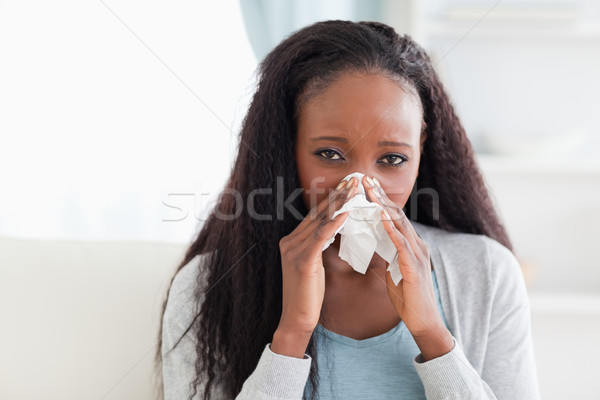 Close up of young woman on sofa blowing her nose Stock photo © wavebreak_media