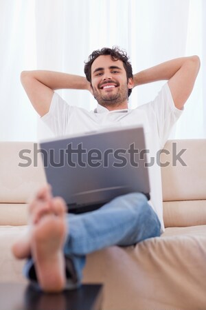 Portrait of a happy man using a laptop in his living room Stock photo © wavebreak_media