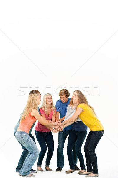 Group of friends about to cheer with their hands stacked smiling as they look at one another Stock photo © wavebreak_media