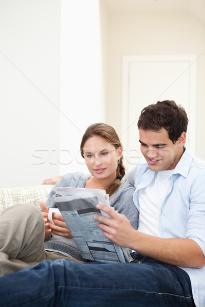 Young Couple embracing while reading a newspaper in a sitting room Stock photo © wavebreak_media