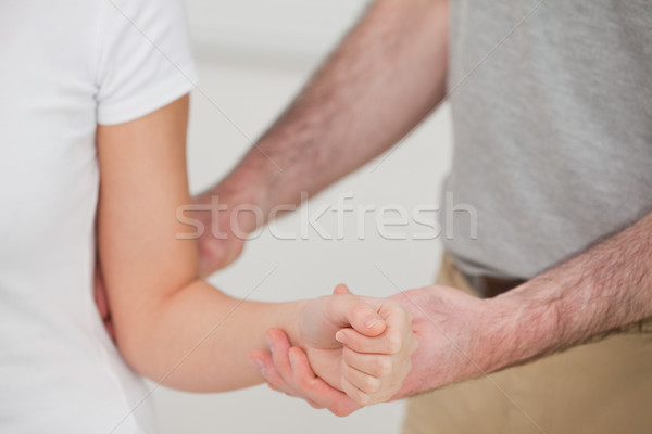 Close-up of a man examining the elbow of a woman in a room Stock photo © wavebreak_media