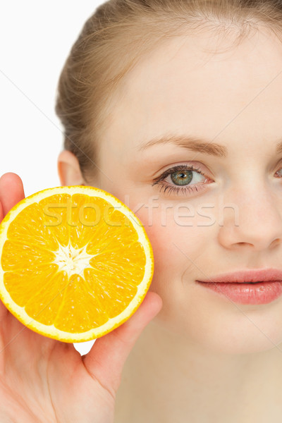 Close up of a blonde-haired girl presenting an orange against white background Stock photo © wavebreak_media