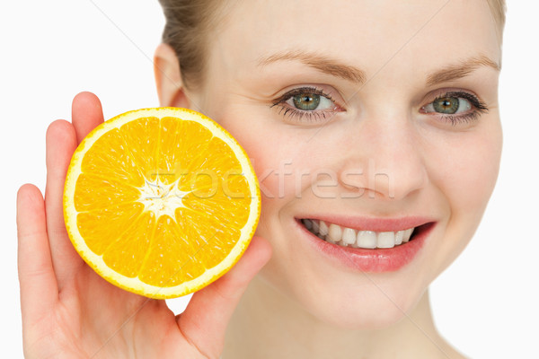 Blond-haired woman presenting an orange against white background Stock photo © wavebreak_media