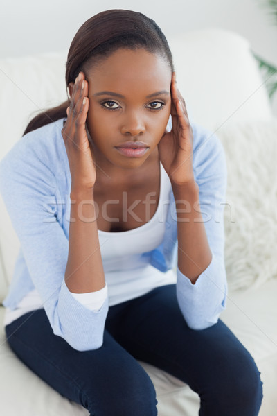 Black woman putting hands on temples in a living room Stock photo © wavebreak_media