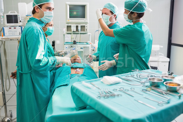 Surgeon operating an uncounscious patient in an operating theater Stock photo © wavebreak_media