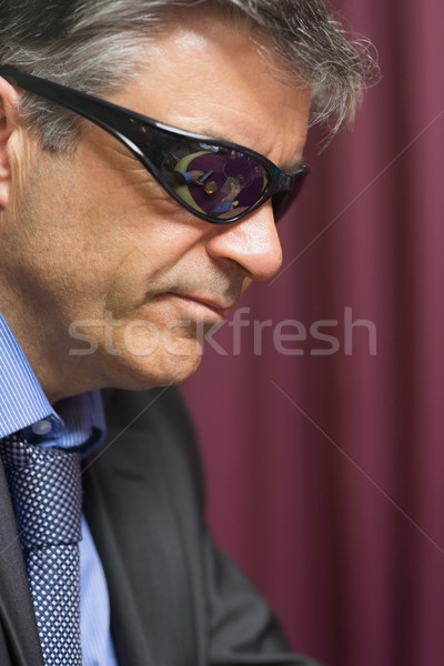 Stock photo: Man wearing sun glasses at the casino looking angry