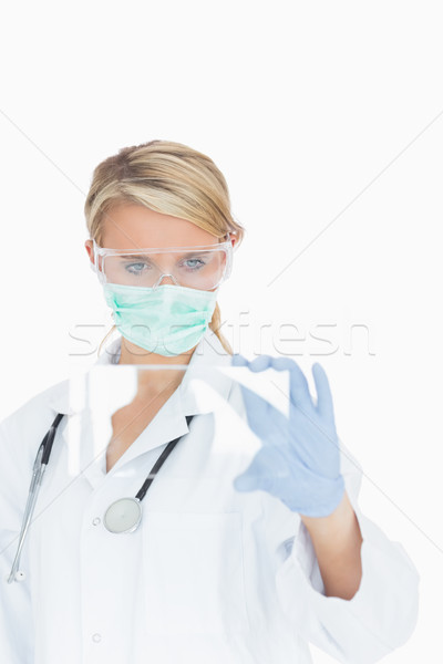 Female doctor wearing surgical gear looking at glass pane Stock photo © wavebreak_media